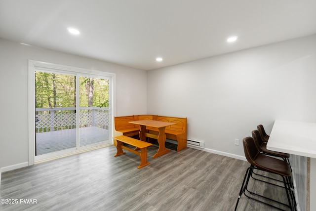 dining space with wood finished floors, recessed lighting, baseboards, and a baseboard heating unit