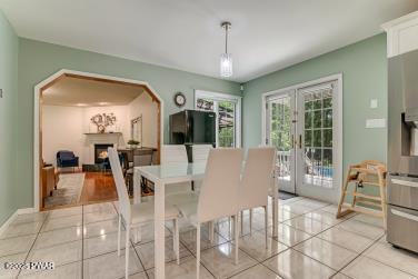 3043 Hemlock Rd, Stroudsburg, PA 18360 - dining room with french doors, light tile patterned flooring, and a fireplace