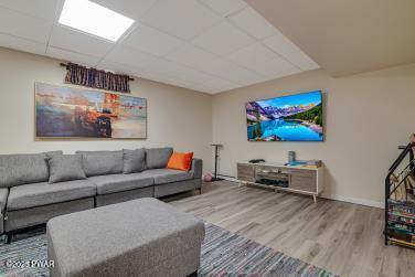3043 Hemlock Rd, Stroudsburg, PA 18360 - living area featuring wood finished floors, a paneled ceiling, and baseboards