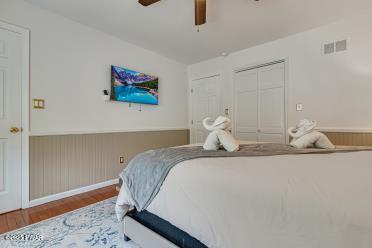 3043 Hemlock Rd, Stroudsburg, PA 18360 - bedroom with wood finished floors, wainscoting, ceiling fan, and baseboards