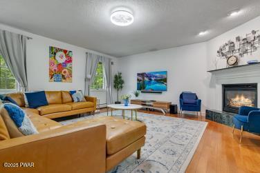3043 Hemlock Rd, Stroudsburg, PA 18360 - living area with a glass covered fireplace and wood finished floors