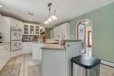 3043 Hemlock Rd, Stroudsburg, PA 18360 - kitchen with double oven, white cabinetry, glass insert cabinets, and recessed lighting