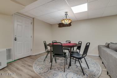3043 Hemlock Rd, Stroudsburg, PA 18360 - dining space featuring light wood-style floors, a paneled ceiling, and baseboards