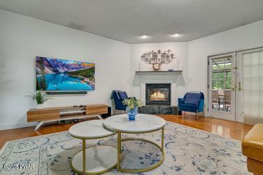 3043 Hemlock Rd, Stroudsburg, PA 18360 - living area featuring wood finished floors, a glass covered fireplace, and baseboards