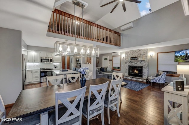 dining area featuring a wall mounted air conditioner, a fireplace, dark wood-style flooring, a towering ceiling, and ceiling fan