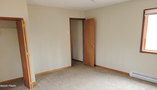 unfurnished bedroom with a closet, light colored carpet, and baseboard heating