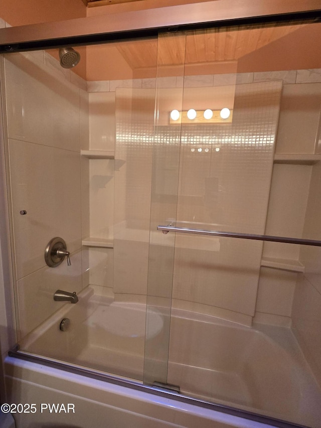 bathroom featuring bath / shower combo with glass door