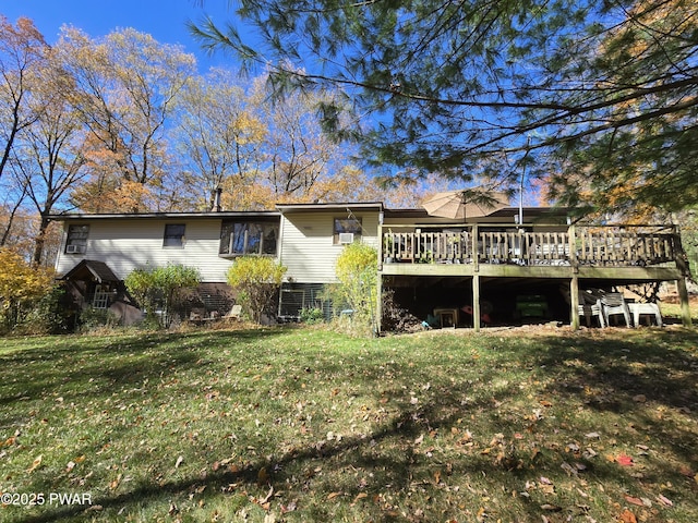 back of property with a wooden deck and a yard