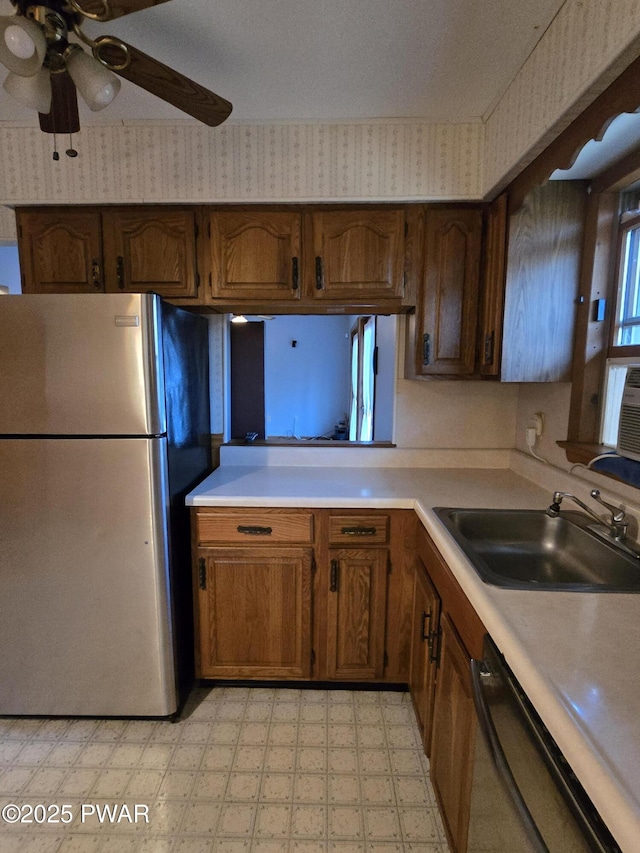 kitchen featuring ceiling fan, sink, stainless steel refrigerator, and black dishwasher