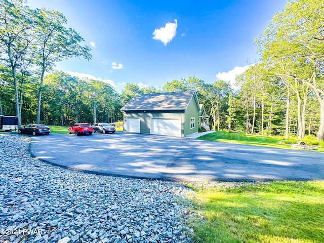 view of side of home with an outbuilding, a garage, and a lawn