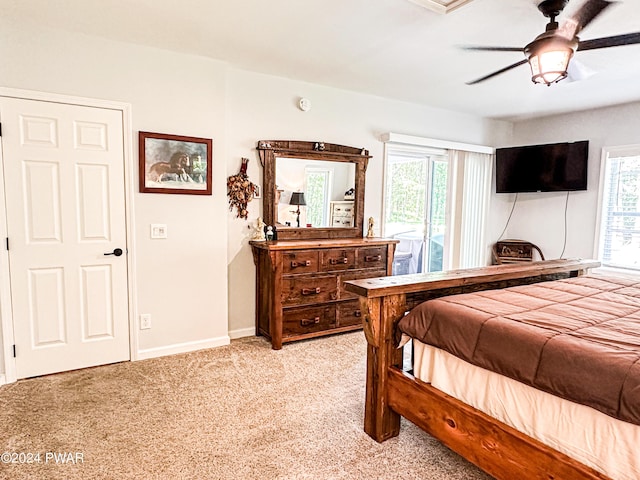 bedroom featuring ceiling fan, light colored carpet, and multiple windows