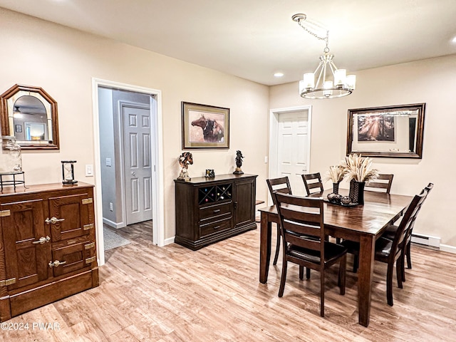 dining room featuring a baseboard heating unit, light hardwood / wood-style flooring, and a chandelier