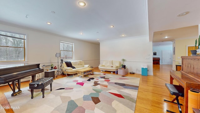 living area with a healthy amount of sunlight, light hardwood / wood-style floors, and crown molding