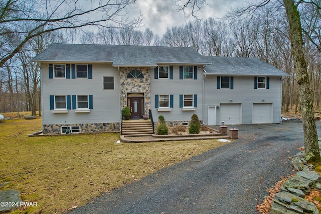 split foyer home with a garage and a front yard