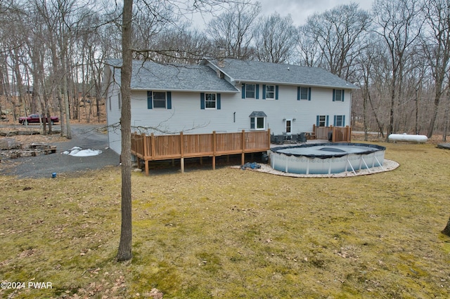 back of property with a yard and a pool side deck