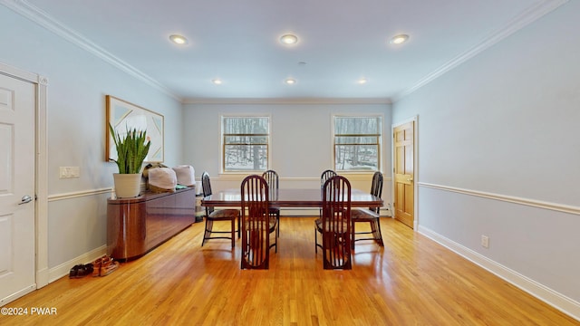 dining room featuring crown molding, light hardwood / wood-style floors, and a baseboard heating unit