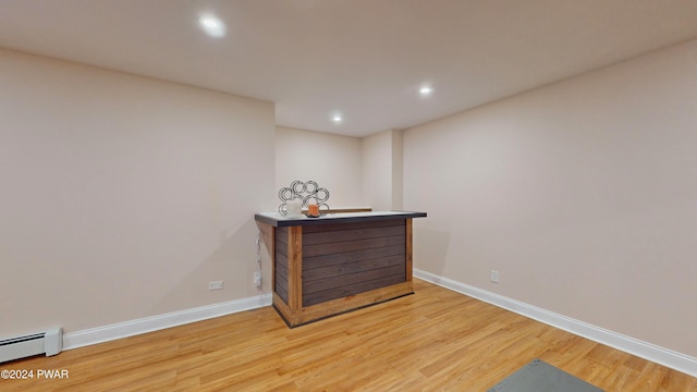 bar featuring hardwood / wood-style floors and a baseboard heating unit