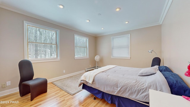 bedroom with wood-type flooring, ornamental molding, and a baseboard heating unit