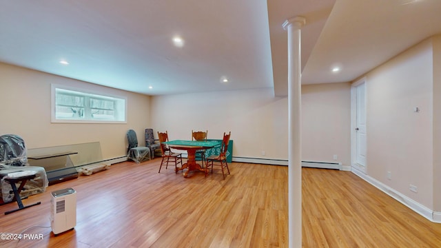 dining area with light wood-type flooring and baseboard heating