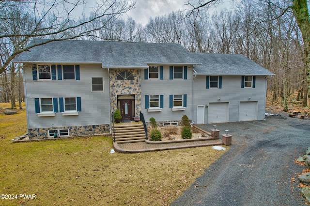 bi-level home featuring a garage and a front yard