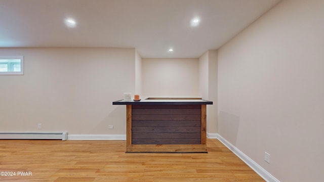 bar featuring light hardwood / wood-style floors and a baseboard heating unit