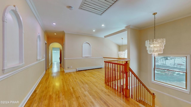 hall featuring baseboard heating, light hardwood / wood-style flooring, ornamental molding, and a notable chandelier