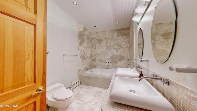 bathroom with toilet, sink, tiled bath, and a baseboard radiator