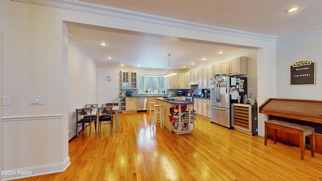 kitchen with stainless steel appliances, beverage cooler, crown molding, a kitchen island, and hanging light fixtures