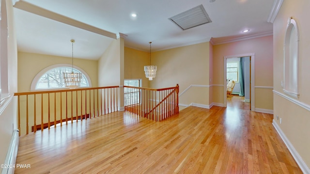 unfurnished room with a notable chandelier, light hardwood / wood-style floors, and plenty of natural light