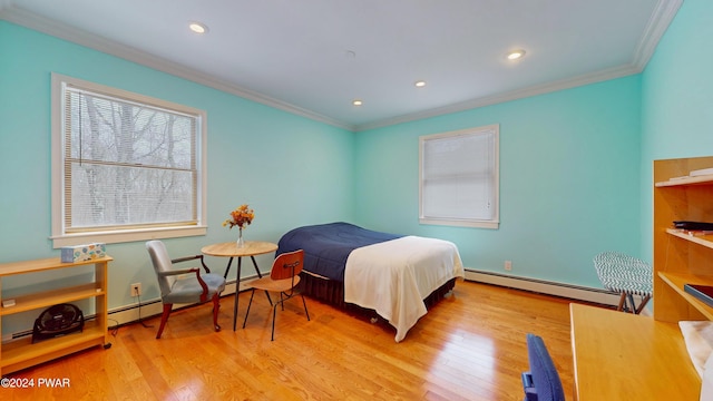 bedroom featuring light wood-type flooring, crown molding, and a baseboard heating unit