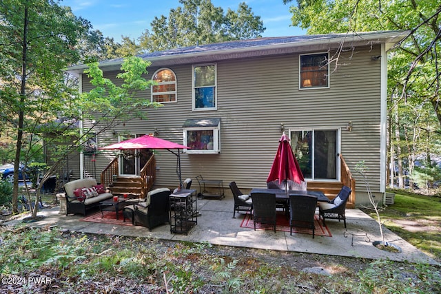 rear view of house with a patio area and an outdoor living space