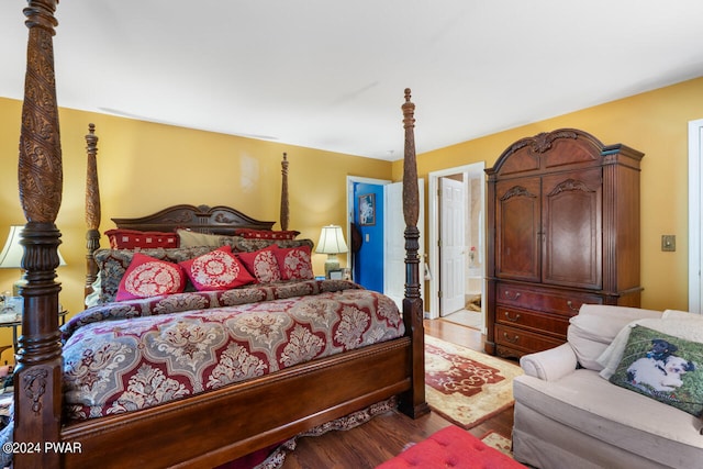 bedroom with ensuite bathroom and light hardwood / wood-style floors