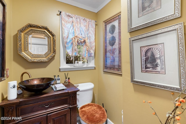 bathroom with vanity, toilet, and crown molding