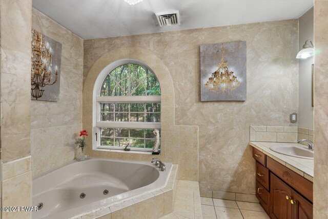 bathroom featuring vanity, tiled bath, tile patterned floors, and a wealth of natural light