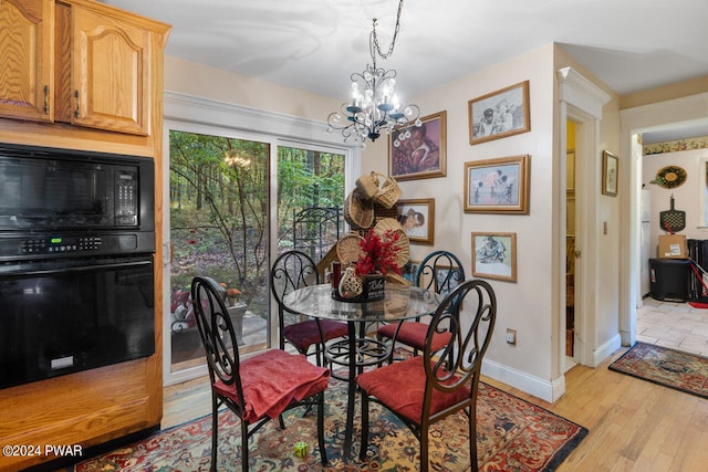 dining space featuring light hardwood / wood-style floors and a notable chandelier