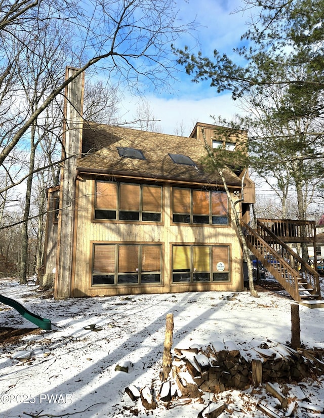 view of snow covered rear of property