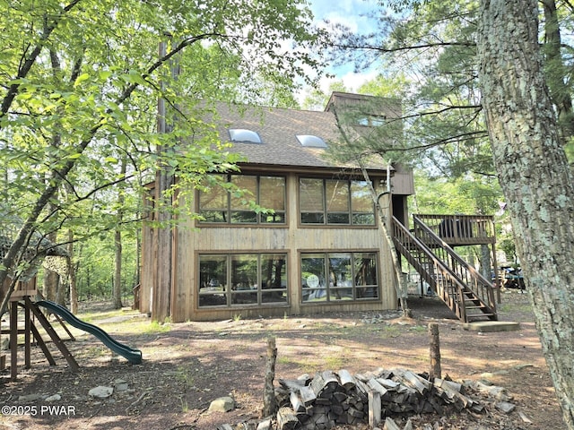 6128 Wales Ct, East Stroudsburg, PA 18301 - rear view of property with a shingled roof, stairway, a wooden deck, and a playground