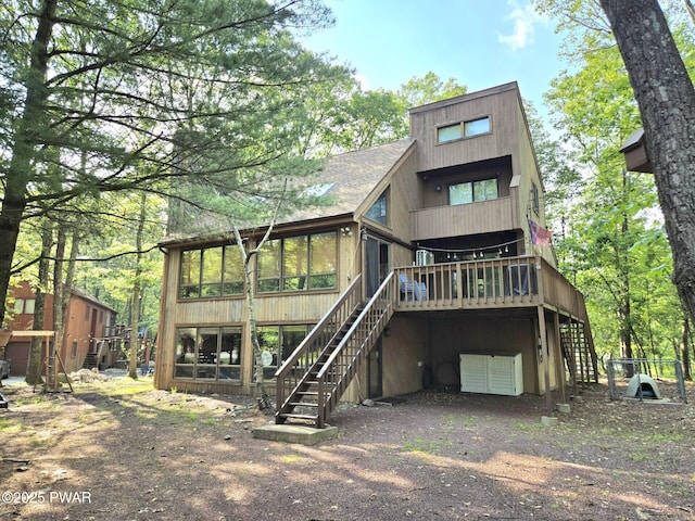 6128 Wales Ct, East Stroudsburg, PA 18301 - back of house with stairway, a sunroom, a deck, dirt driveway, and an attached garage