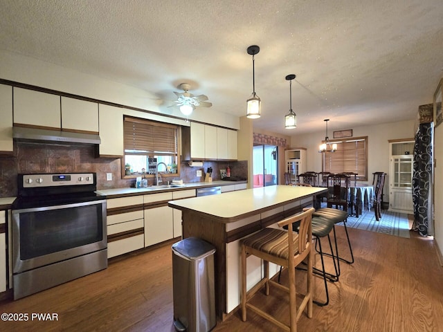 kitchen featuring white cabinets, stainless steel appliances, a kitchen island, and pendant lighting