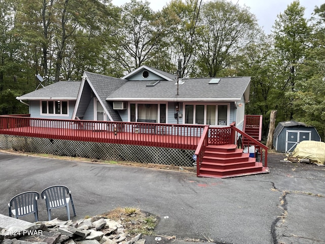 view of front facade featuring a storage unit and a wooden deck