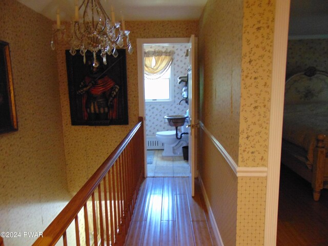 hallway featuring hardwood / wood-style floors and a chandelier