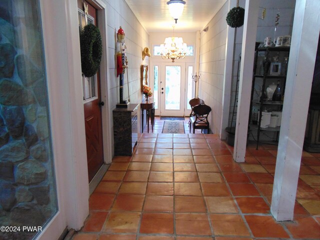 tiled foyer featuring a chandelier