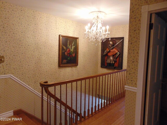 stairway featuring hardwood / wood-style floors and a chandelier