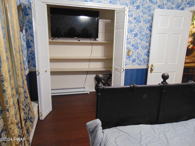 bedroom featuring baseboard heating and dark hardwood / wood-style floors