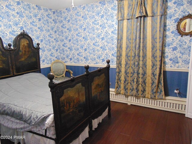 bedroom with baseboard heating and dark hardwood / wood-style flooring