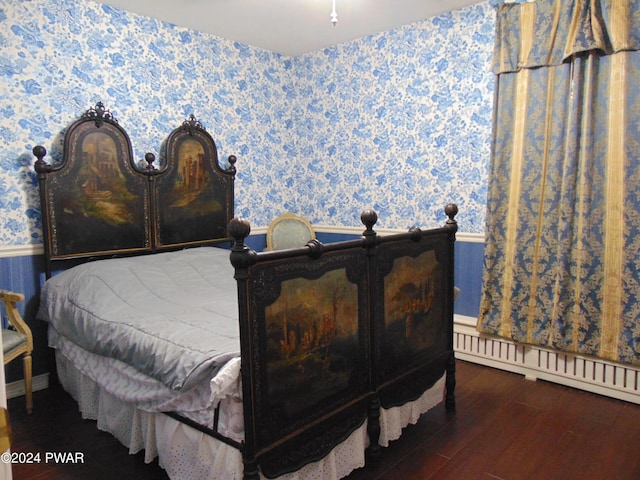 bedroom featuring dark hardwood / wood-style flooring and a baseboard heating unit