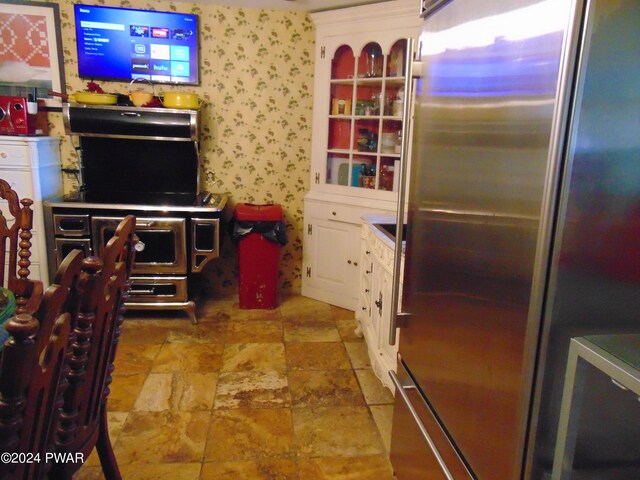 kitchen featuring stainless steel fridge and white cabinetry