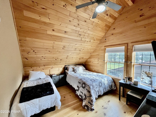 bedroom with ceiling fan, lofted ceiling, wooden walls, wood ceiling, and light wood-type flooring