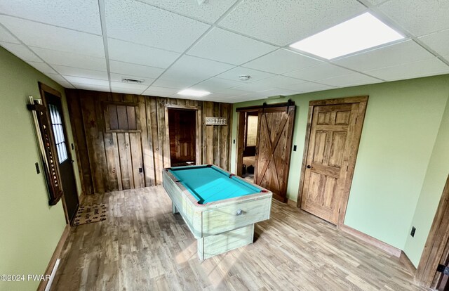 rec room with a barn door, billiards, a paneled ceiling, and wood walls