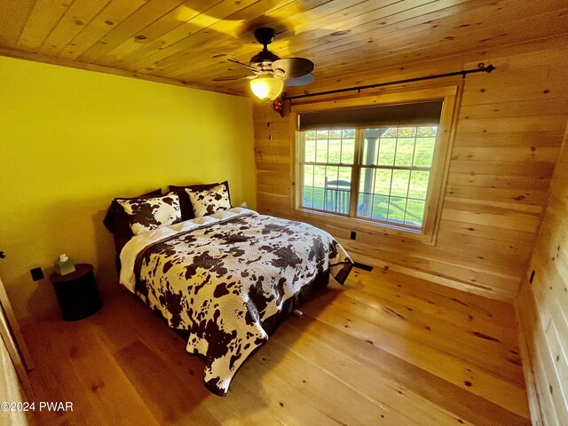 bedroom featuring crown molding, ceiling fan, light hardwood / wood-style flooring, and wooden ceiling